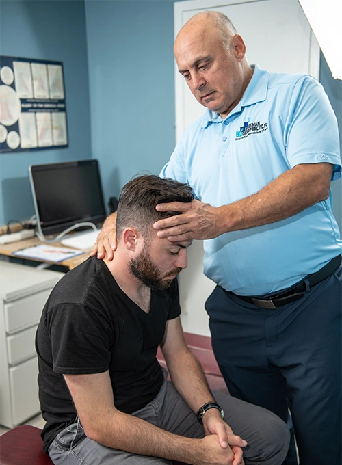 Chiropractor Baltimore MD Mark Stutman Assessing Patients Neck
